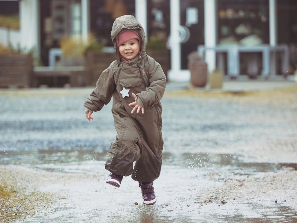 child playing in a puddle