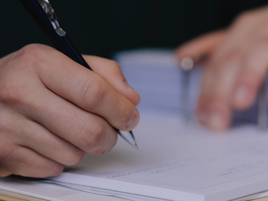 someone writing on paper